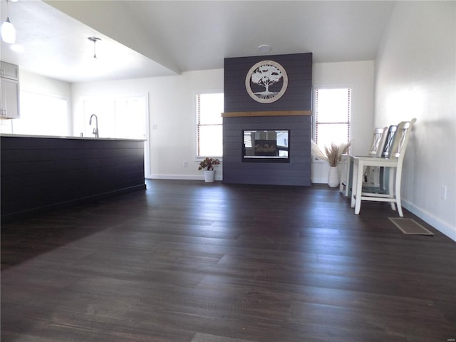 1002 Cypress Dr, Rolla, MO 65401 - unfurnished living room with baseboards, a fireplace, dark wood-type flooring, and a sink