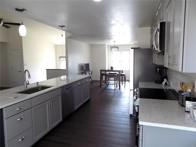 1002 Cypress Dr, Rolla, MO 65401 - kitchen featuring a sink, appliances with stainless steel finishes, dark wood-style floors, decorative backsplash, and hanging light fixtures