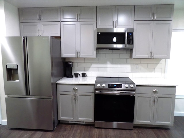 1002 Cypress Dr, Rolla, MO 65401 - kitchen featuring appliances with stainless steel finishes, gray cabinetry, dark wood-style flooring, and tasteful backsplash