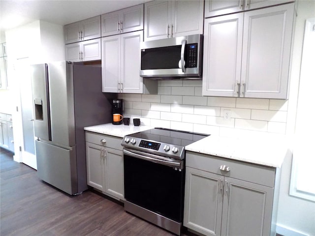 1002 Cypress Dr, Rolla, MO 65401 - kitchen with appliances with stainless steel finishes, gray cabinetry, dark wood-type flooring, and decorative backsplash