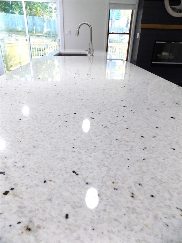 1002 Cypress Dr, Rolla, MO 65401 - kitchen view of a sink, light stone countertops, and a fireplace