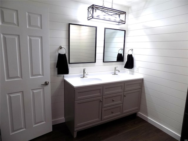 1002 Cypress Dr, Rolla, MO 65401 - bathroom featuring wood finished floors, double vanity, and wood walls