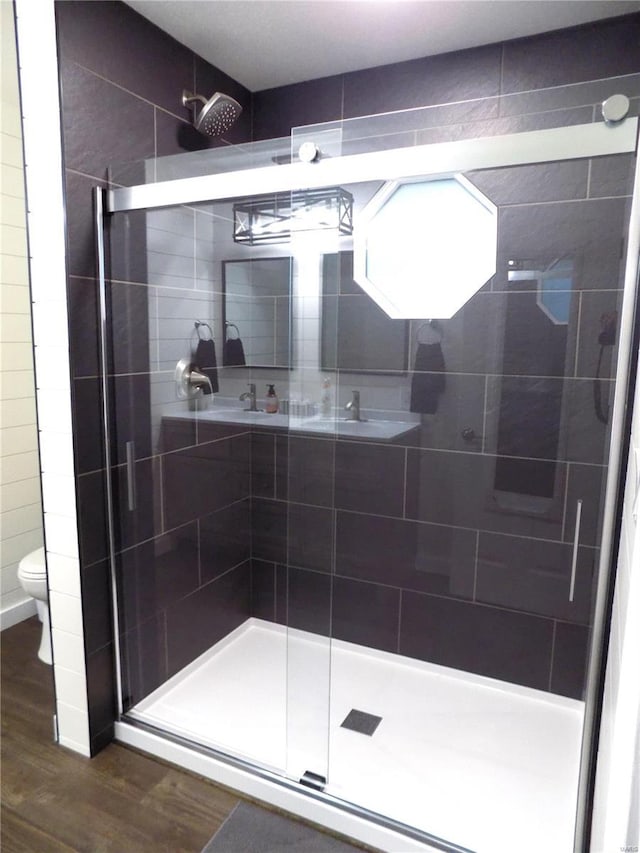 1002 Cypress Dr, Rolla, MO 65401 - bathroom with wood finished floors, a shower stall, and toilet