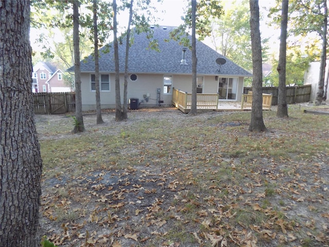 1002 Cypress Dr, Rolla, MO 65401 - back of house with a wooden deck, a fenced backyard, cooling unit, and roof with shingles