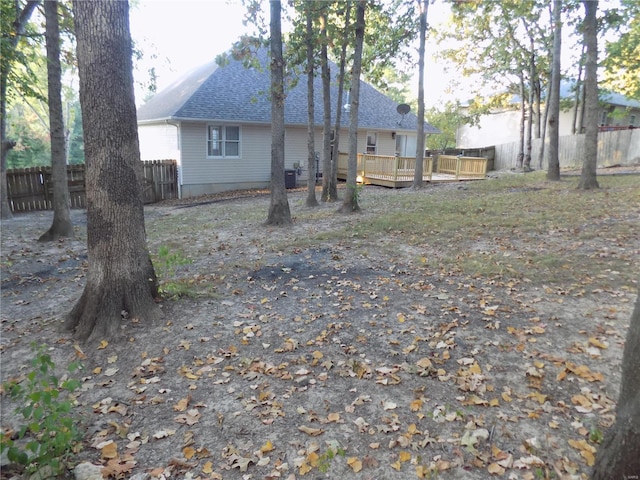 1002 Cypress Dr, Rolla, MO 65401 - back of house with a wooden deck, roof with shingles, and a fenced backyard