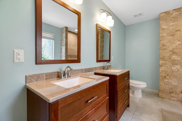 bathroom featuring two vanities, tile patterned flooring, and toilet