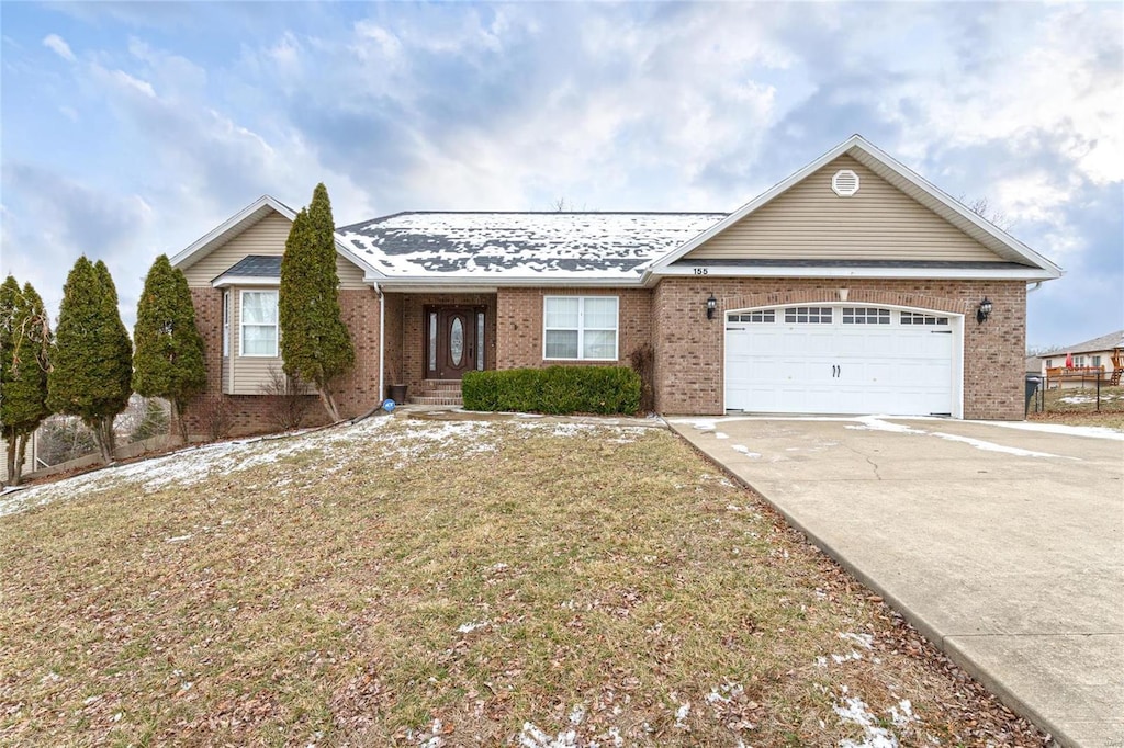 ranch-style house with brick siding, driveway, an attached garage, and a front lawn