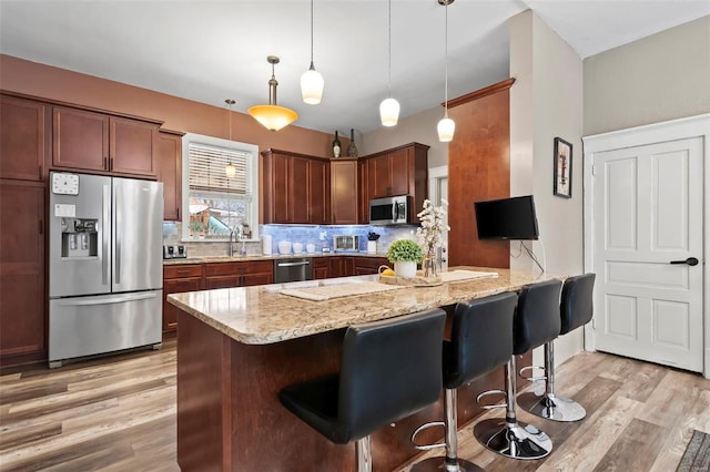 821 N State St, Litchfield, IL 62056 - kitchen featuring appliances with stainless steel finishes, decorative backsplash, light wood-style floors, and a sink