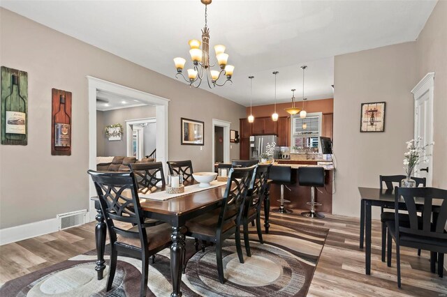 821 N State St, Litchfield, IL 62056 - dining area with light wood-style flooring, a chandelier, and baseboards