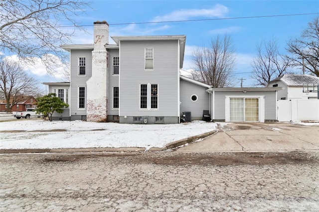 821 N State St, Litchfield, IL 62056 - view of front facade with a chimney, central AC unit, fence, and a garage