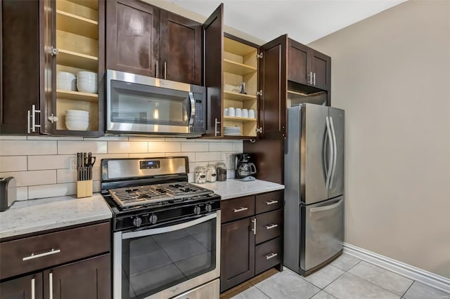kitchen featuring appliances with stainless steel finishes, tasteful backsplash, dark brown cabinetry, and light stone counters