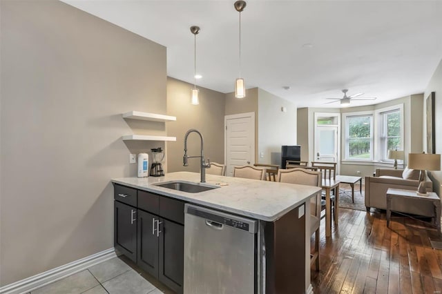 kitchen with stainless steel dishwasher, a sink, open floor plan, open shelves, and baseboards