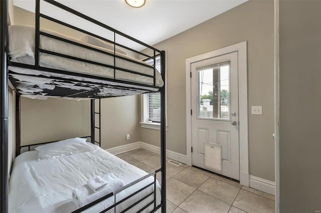 bedroom featuring baseboards and light tile patterned floors