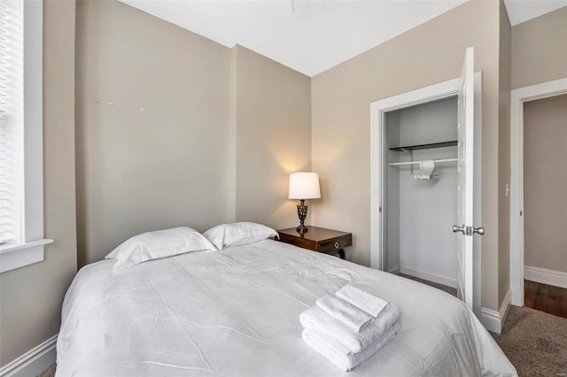 carpeted bedroom featuring a closet and baseboards