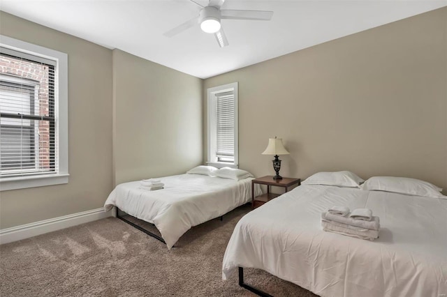 carpeted bedroom featuring baseboards and a ceiling fan