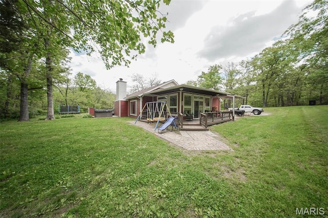 12455 Jefferys Pl, Rolla, MO 65401 - rear view of house with a sunroom, a chimney, a lawn, and a wooden deck
