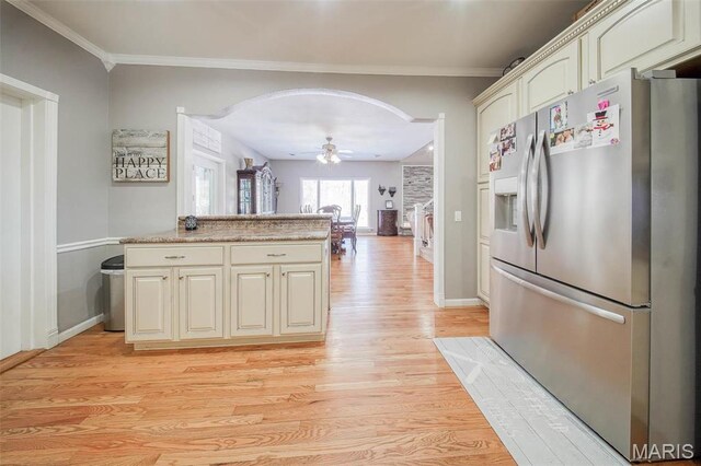 12455 Jefferys Pl, Rolla, MO 65401 - kitchen with stainless steel fridge, cream cabinetry, light wood-style flooring, arched walkways, and ceiling fan