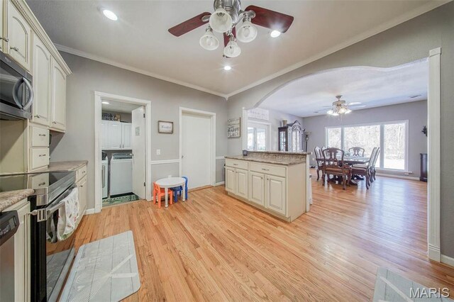 12455 Jefferys Pl, Rolla, MO 65401 - kitchen featuring a ceiling fan, light wood-style flooring, stainless steel appliances, washing machine and dryer, and arched walkways
