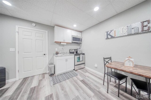 12455 Jefferys Pl, Rolla, MO 65401 - kitchen featuring stainless steel appliances, white cabinetry, a sink, light wood-style floors, and recessed lighting
