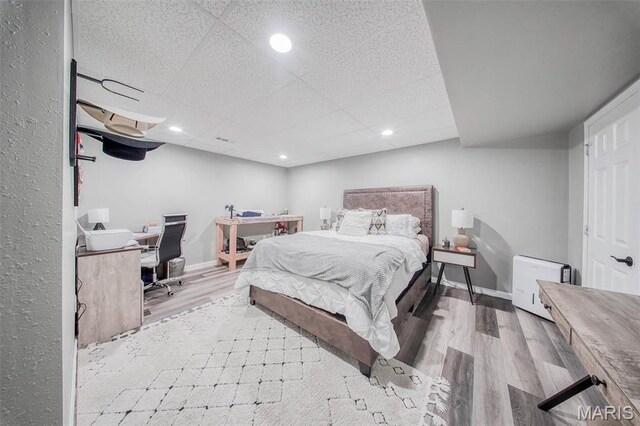 12455 Jefferys Pl, Rolla, MO 65401 - bedroom with wood finished floors, an office area, a paneled ceiling, recessed lighting, and baseboards