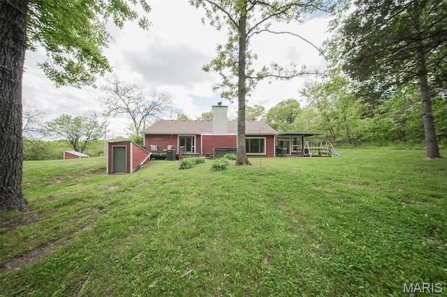 12455 Jefferys Pl, Rolla, MO 65401 - back of property featuring a yard, a storage shed, a chimney, an outbuilding, and a sunroom