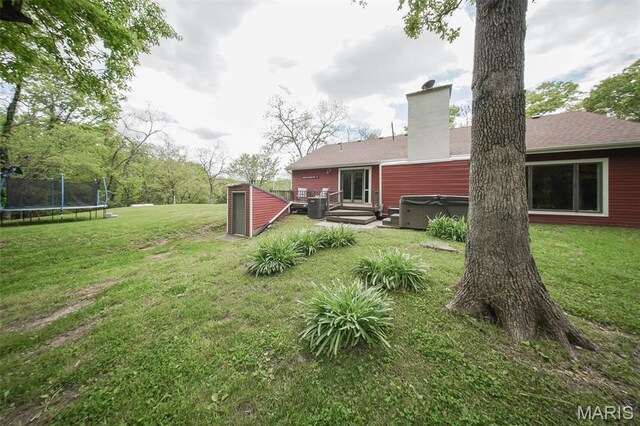 12455 Jefferys Pl, Rolla, MO 65401 - view of grassy yard with a hot tub, a trampoline, central air condition unit, and a wooden deck
