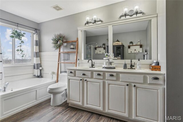 8038 Fox Holw, Barnhart, MO 63012 - bathroom featuring a bath, double vanity, wood finished floors, toilet, and a shower