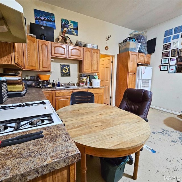 12124 Hamilton Hollow Rd, Sullivan, MO 63080 - kitchen with exhaust hood, concrete flooring, stove, freestanding refrigerator, and brown cabinetry