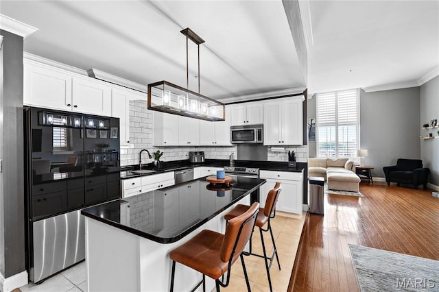 kitchen featuring appliances with stainless steel finishes, crown molding, white cabinets, tasteful backsplash, and baseboards