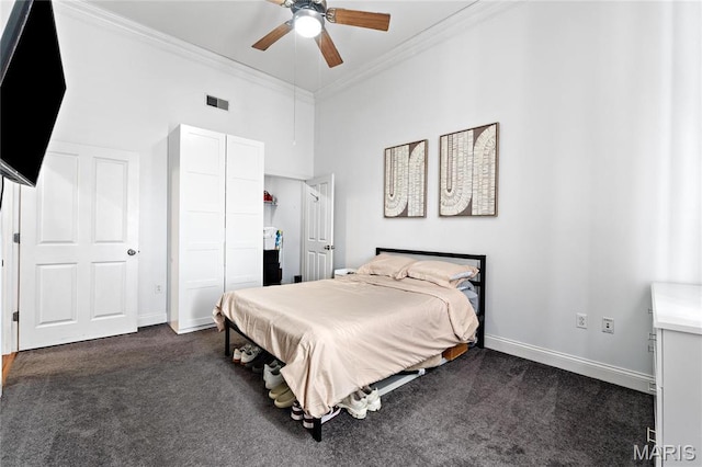 bedroom with dark colored carpet, crown molding, baseboards, a closet, and ceiling fan