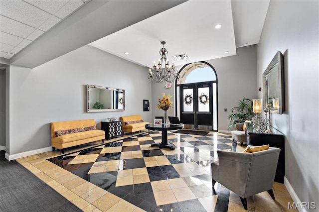 tiled entrance foyer with a chandelier, baseboards, and recessed lighting
