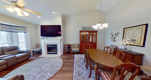 112 Summit Rdg, Maryville, IL 62062 - dining space featuring vaulted ceiling, wood finished floors, a fireplace with flush hearth, a chandelier, and a ceiling fan