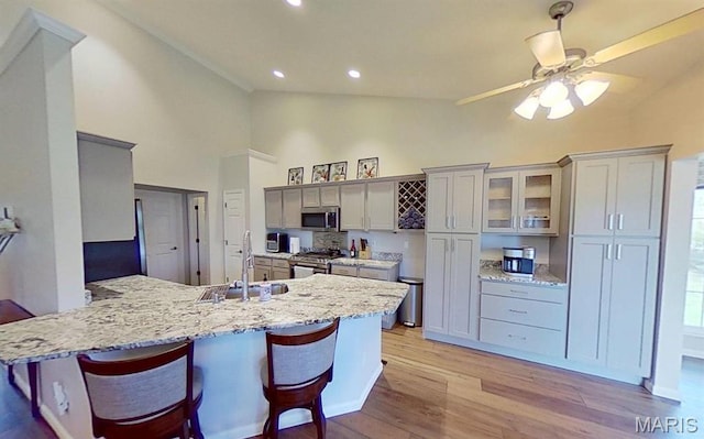 112 Summit Rdg, Maryville, IL 62062 - kitchen with a sink, stainless steel appliances, high vaulted ceiling, a peninsula, and light wood-type flooring