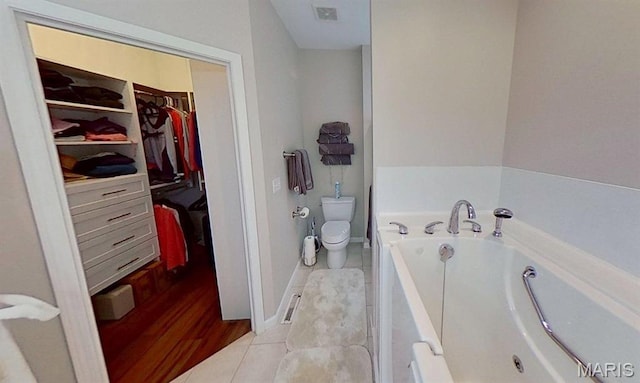 112 Summit Rdg, Maryville, IL 62062 - bathroom featuring toilet, a bath, a walk in closet, baseboards, and tile patterned floors