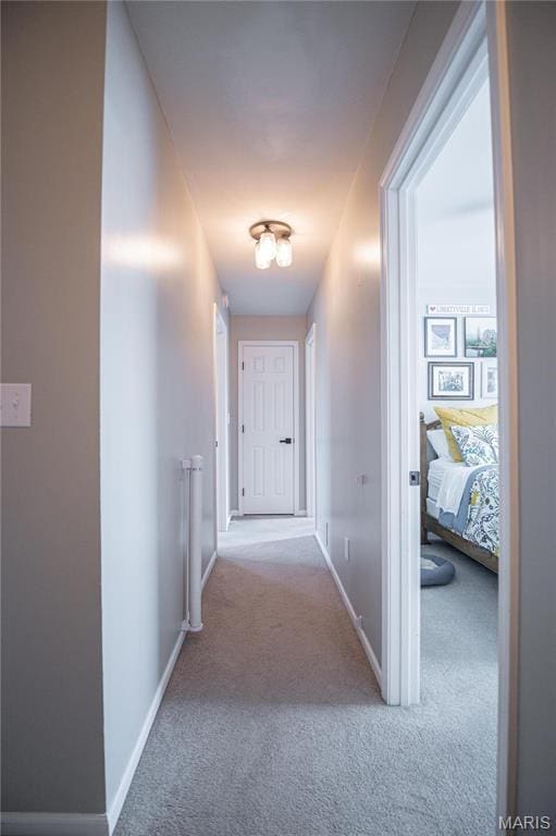 corridor with carpet floors and baseboards