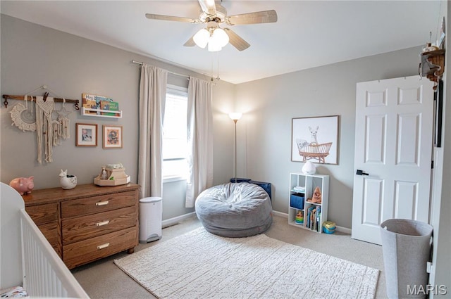 bedroom with light colored carpet, a ceiling fan, and baseboards