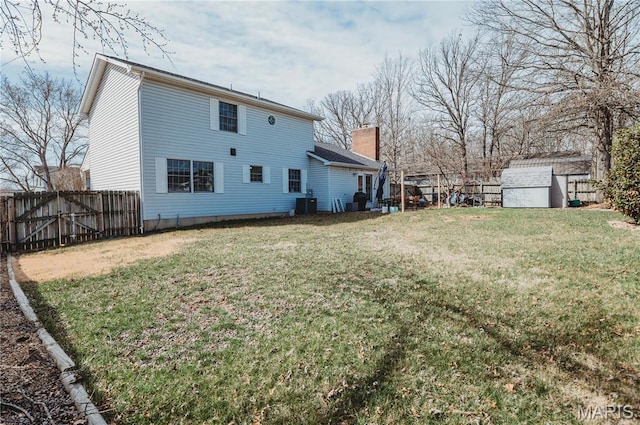 back of house featuring a shed, a chimney, and an outdoor structure