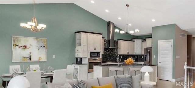 322 Pointe Loma Blvd, Lake St Louis, MO 63367 - kitchen with appliances with stainless steel finishes, a chandelier, dark countertops, high vaulted ceiling, and wall chimney range hood