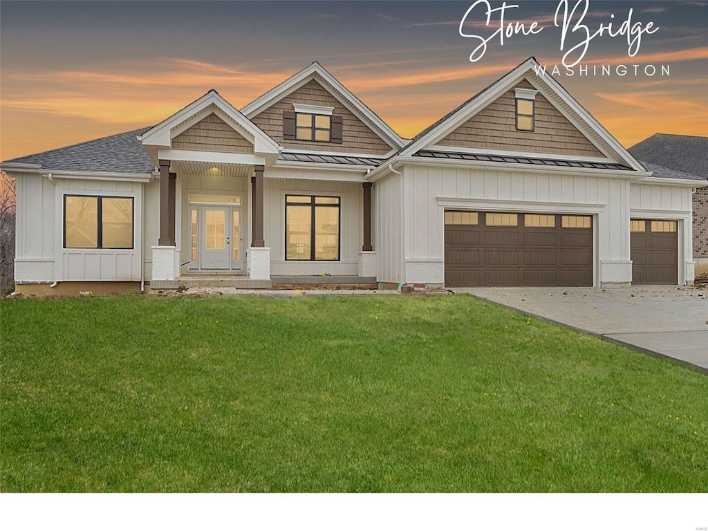 2313 Clare Ct Unit 70Stb, Washington, MO 63090 - view of front of home featuring a standing seam roof, board and batten siding, an attached garage, a lawn, and driveway