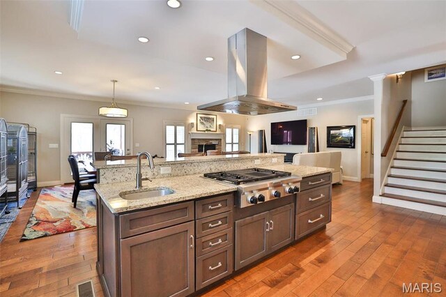 1120 Franklin Ave, Edwardsville, IL 62025 - kitchen with island exhaust hood, stainless steel gas cooktop, crown molding, hardwood / wood-style floors, and light stone countertops