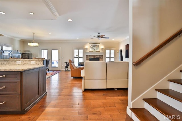 1120 Franklin Ave, Edwardsville, IL 62025 - living room featuring ceiling fan, crown molding, stairs, plenty of natural light, and light wood-type flooring