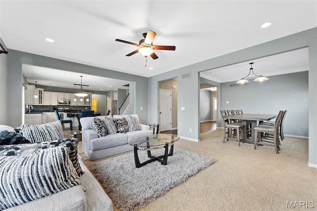 615 Derby Way Dr, Wentzville, MO 63385 - living room with stairs, a ceiling fan, light colored carpet, and recessed lighting