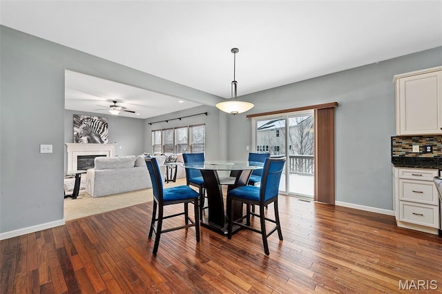 615 Derby Way Dr, Wentzville, MO 63385 - dining area featuring dark wood finished floors, a glass covered fireplace, and ceiling fan