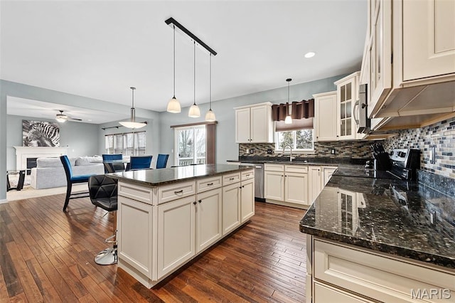 615 Derby Way Dr, Wentzville, MO 63385 - kitchen featuring stainless steel appliances, backsplash, dark wood-style flooring, a fireplace, and ceiling fan