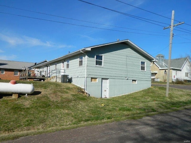 view of home's exterior featuring a yard, central air condition unit, and a wooden deck