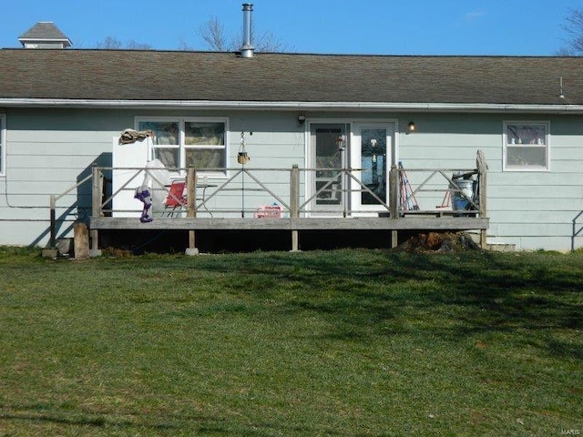 rear view of property with a yard, a shingled roof, and a wooden deck