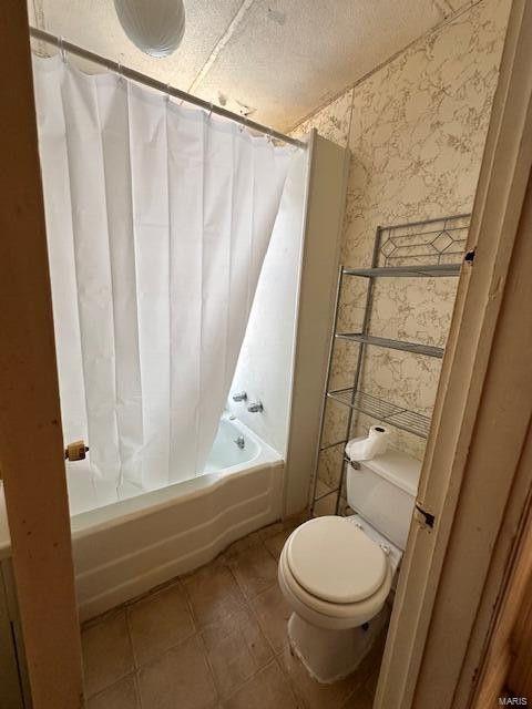 full bathroom with wallpapered walls, toilet, shower / tub combo, and tile patterned floors
