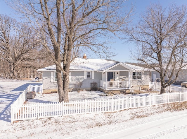 view of front of home with a porch, a chimney, and a fenced front yard