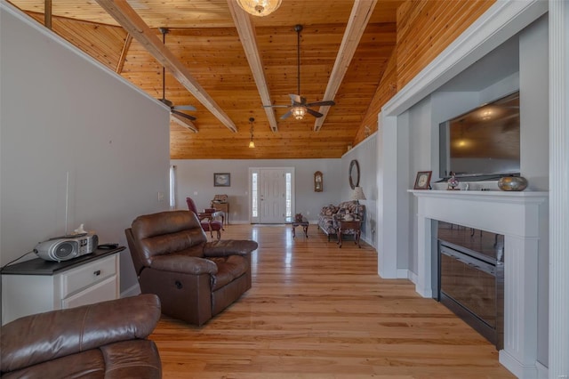 living area with wood ceiling, a ceiling fan, light wood-style floors, a glass covered fireplace, and baseboards