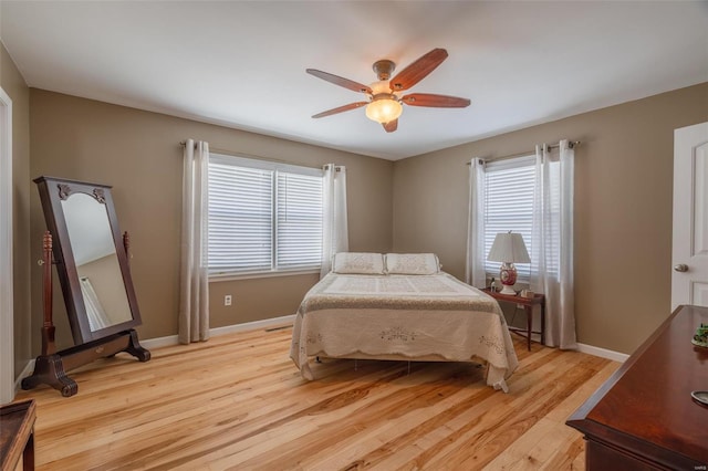 bedroom featuring light wood-style flooring, baseboards, and ceiling fan